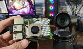A Raspberry Pi 5 kept near an Obsbot Tail Air webcam, with a PC in the background