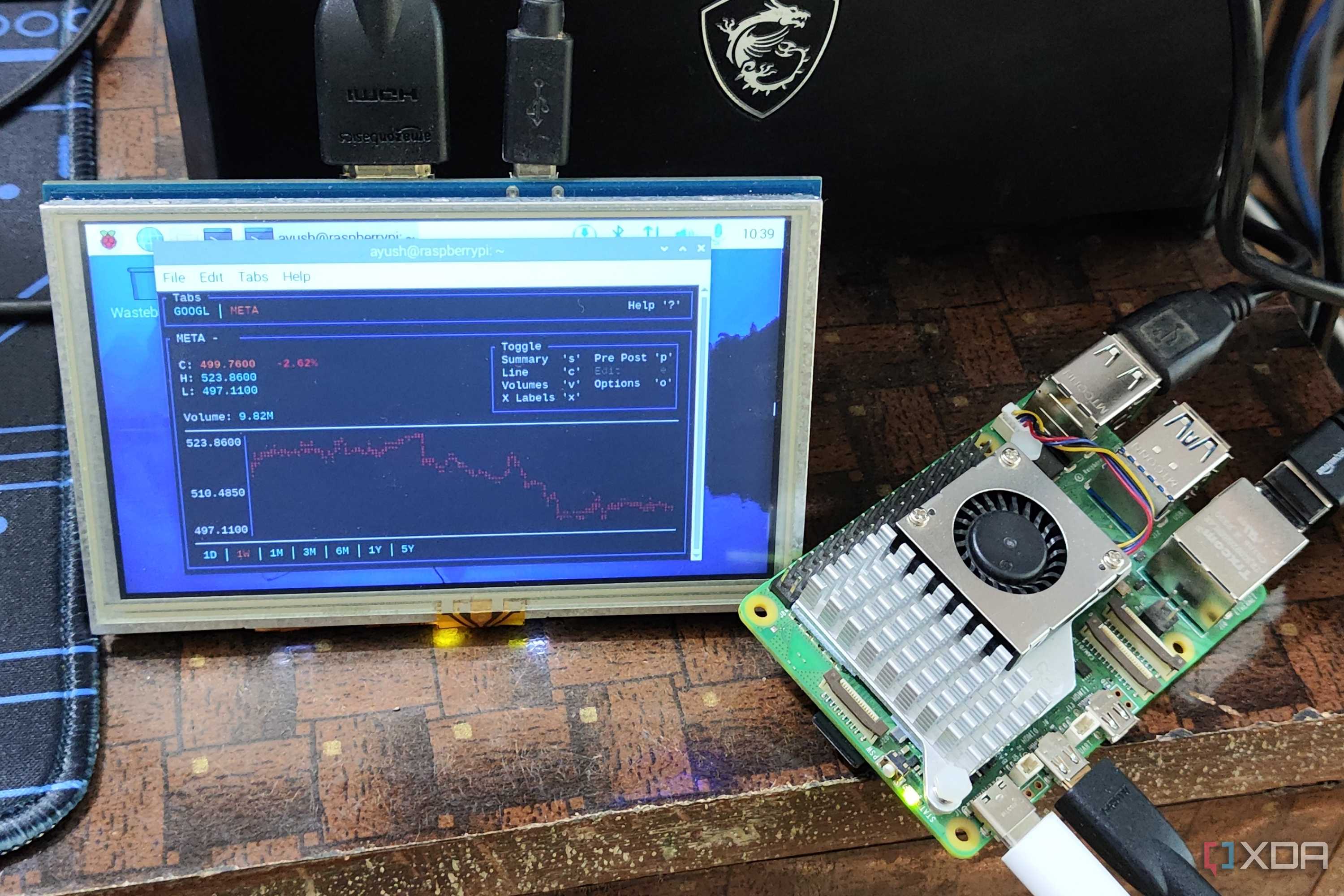 A Raspberry Pi 5 placed next to a portable screen running Tickrs