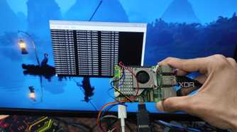 A person holding a Raspberry Pi 5 with a BME280 sensor attached to it in front of a screen