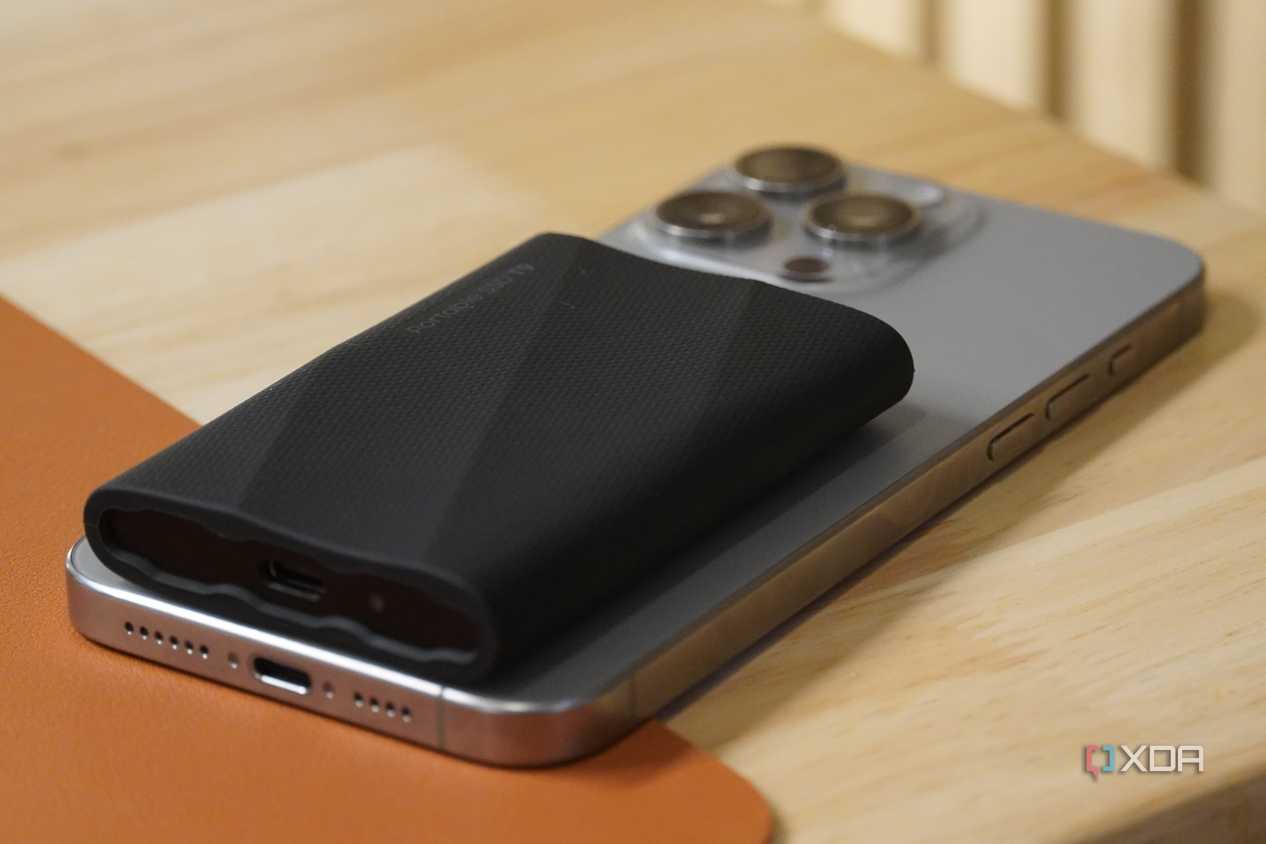 A side view of a Samsung SSD on top of an iPhone.