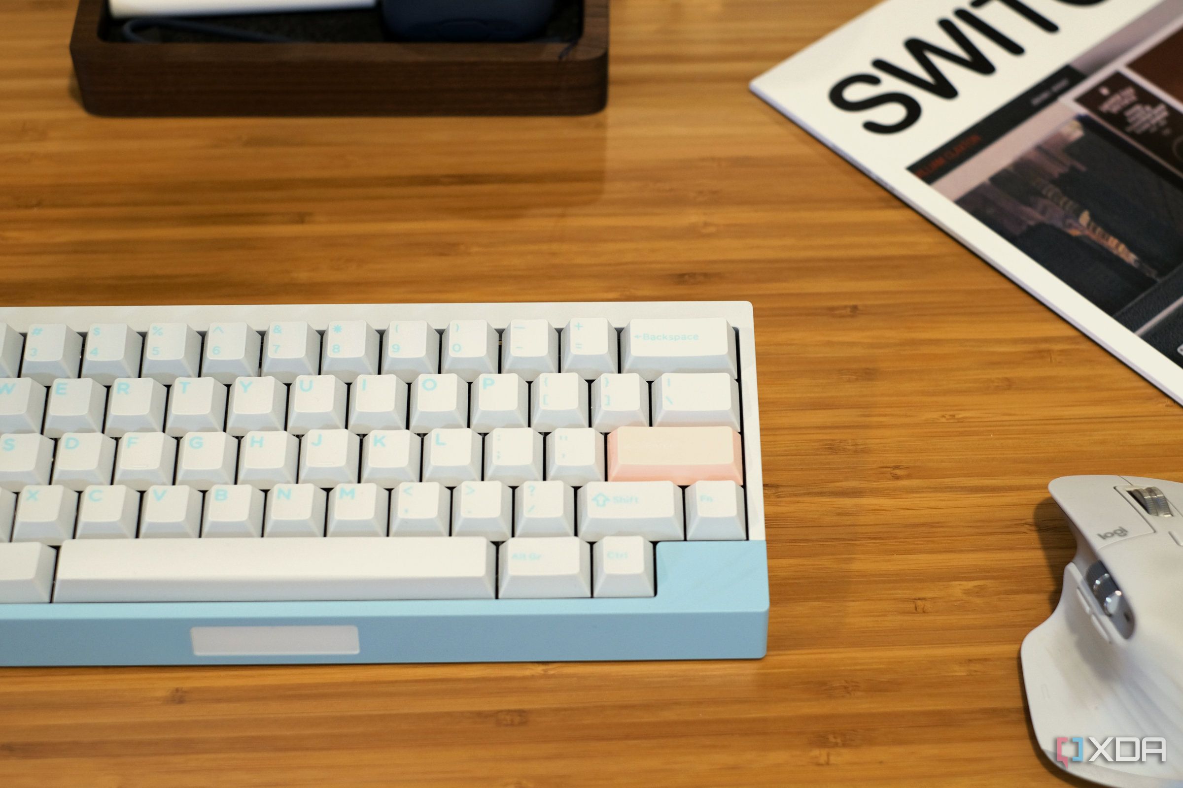 compact mechanical keyboard, wireless mouse, and other accessories arranged on a wooden desk
