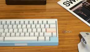 compact mechanical keyboard, wireless mouse, and other accessories arranged on a wooden desk