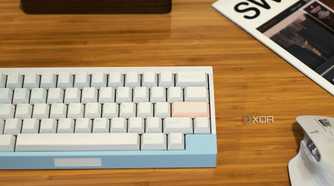 compact mechanical keyboard, wireless mouse, and other accessories arranged on a wooden desk