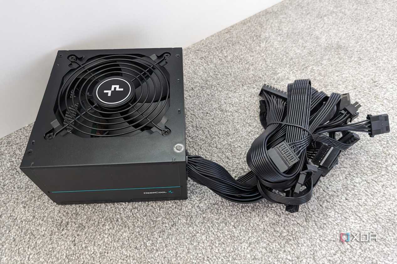 The underside of a DeepCool PM500D power supply with non-modular cables bundled together