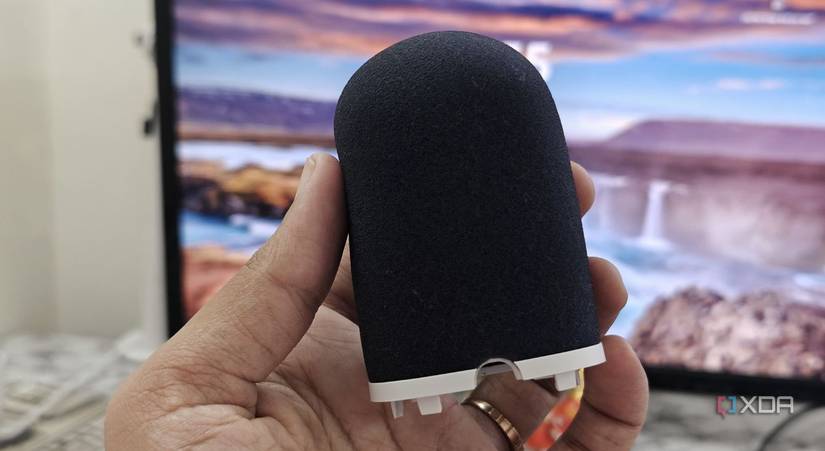 An image showing a person holding the foam pop filter attachment of the Wave Neo microphone.