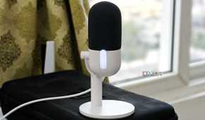 An image showing the Wave Neo microphone kept on a keyboard carrying case next to a window.