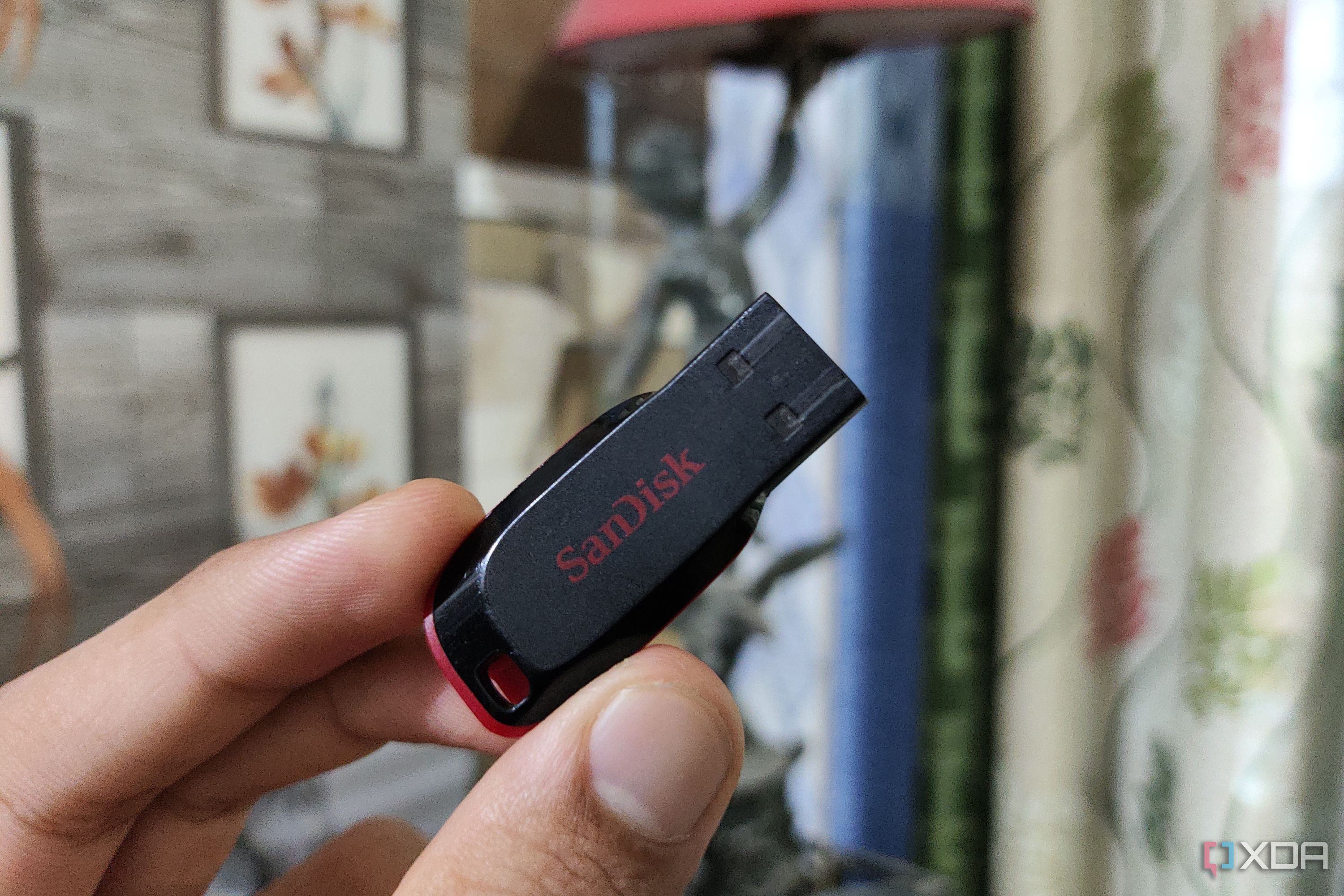 A person holding a SanDisk flash drive
