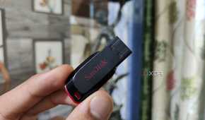 A person holding a SanDisk flash drive