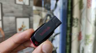 A person holding a SanDisk flash drive