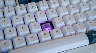 Cloe-up of the Keychron Q1 HE with one of the keycaps removed and a purple light on the exposed switch