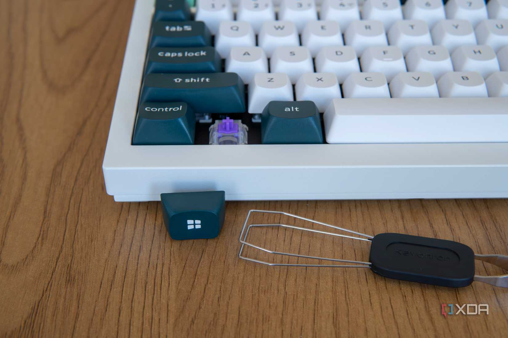 Close-up of a removed keycap next to the Keychron Q1 HE and the included keycap puller