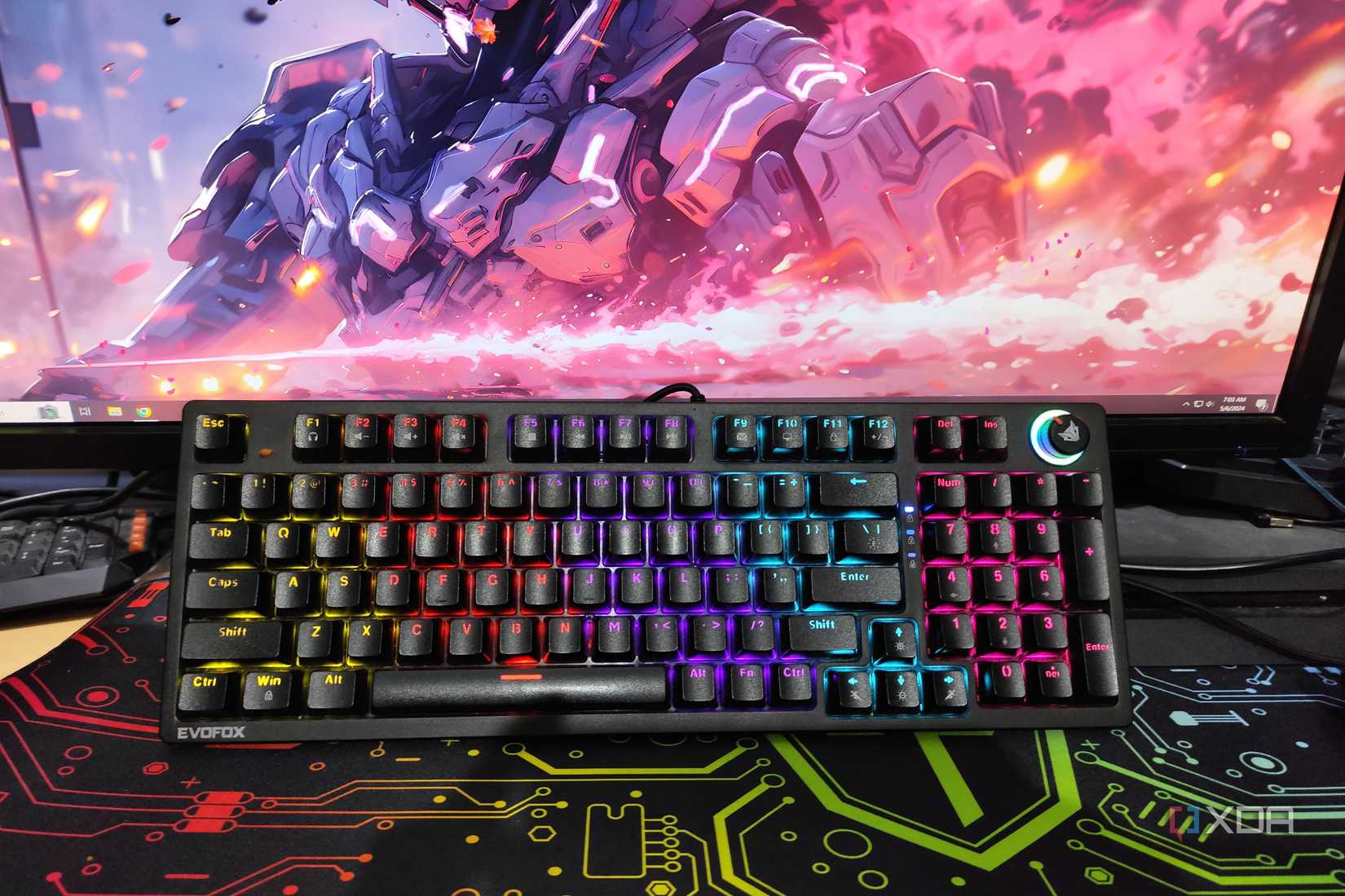 A mechanical keyboard resting against a monitor
