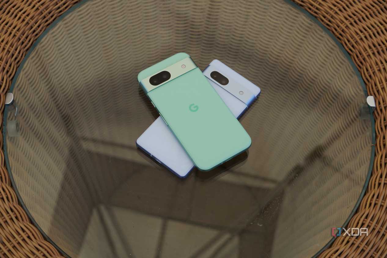 The Pixel 8a and Pixel 7a stacked on a glass table.
