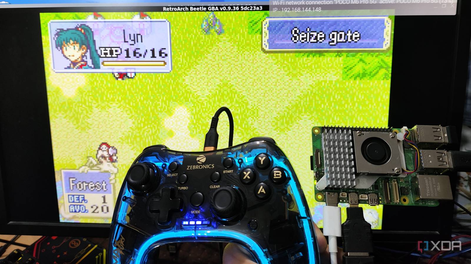 A Raspberry Pi 5 and a controller held in front of a PC screen