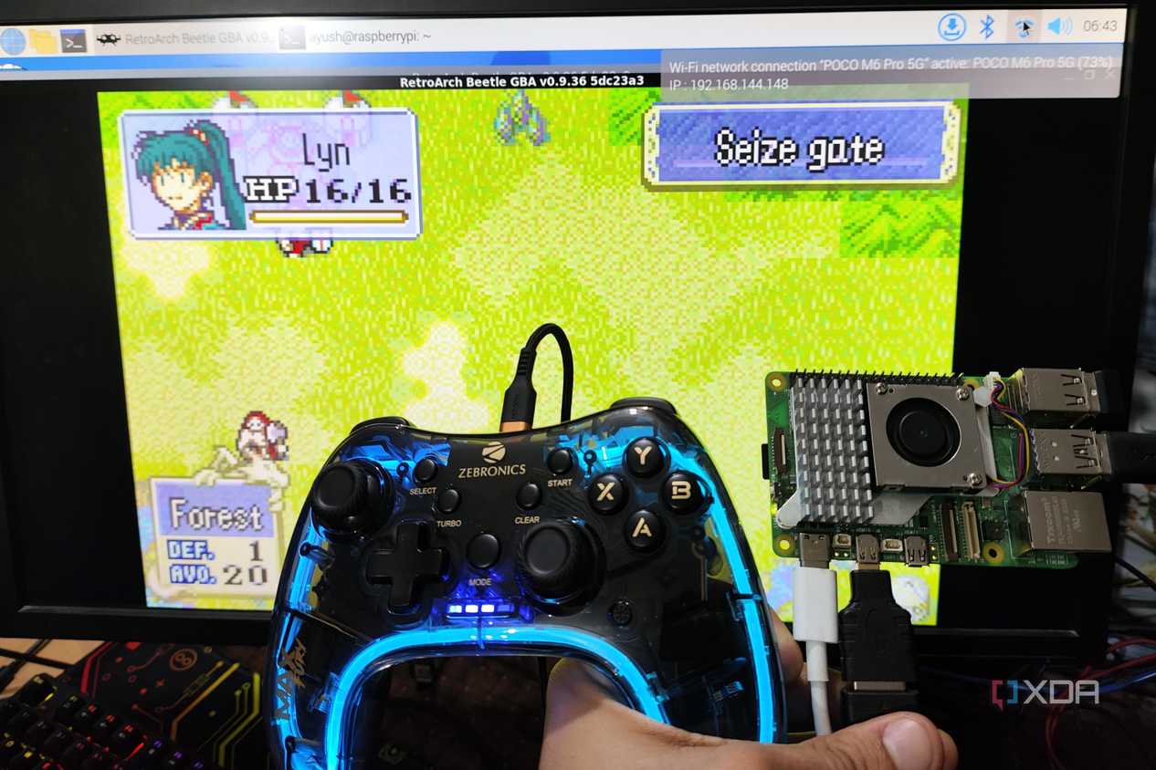 A Raspberry Pi 5 and a controller held in front of a PC screen