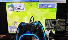 A Raspberry Pi 5 and a controller held in front of a PC screen