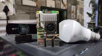 A Raspberry Pi 5 placed next to a webcam and a bulb