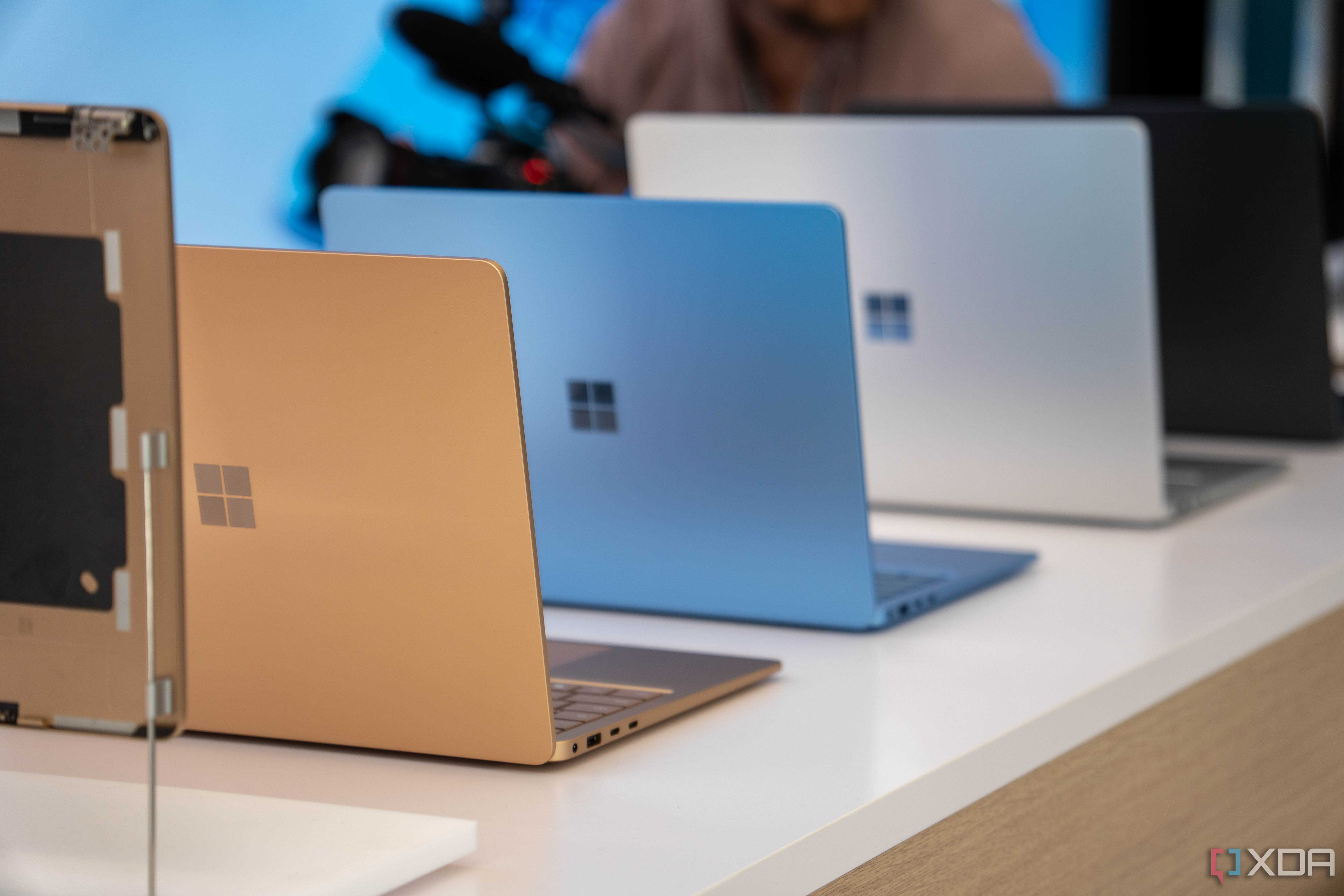 Surface laptops in multiple colors placed on a white surface