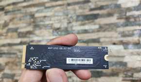 A person holding the SSD included with the Aiffro K100 NAS