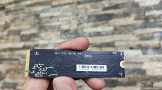 A person holding the SSD included with the Aiffro K100 NAS