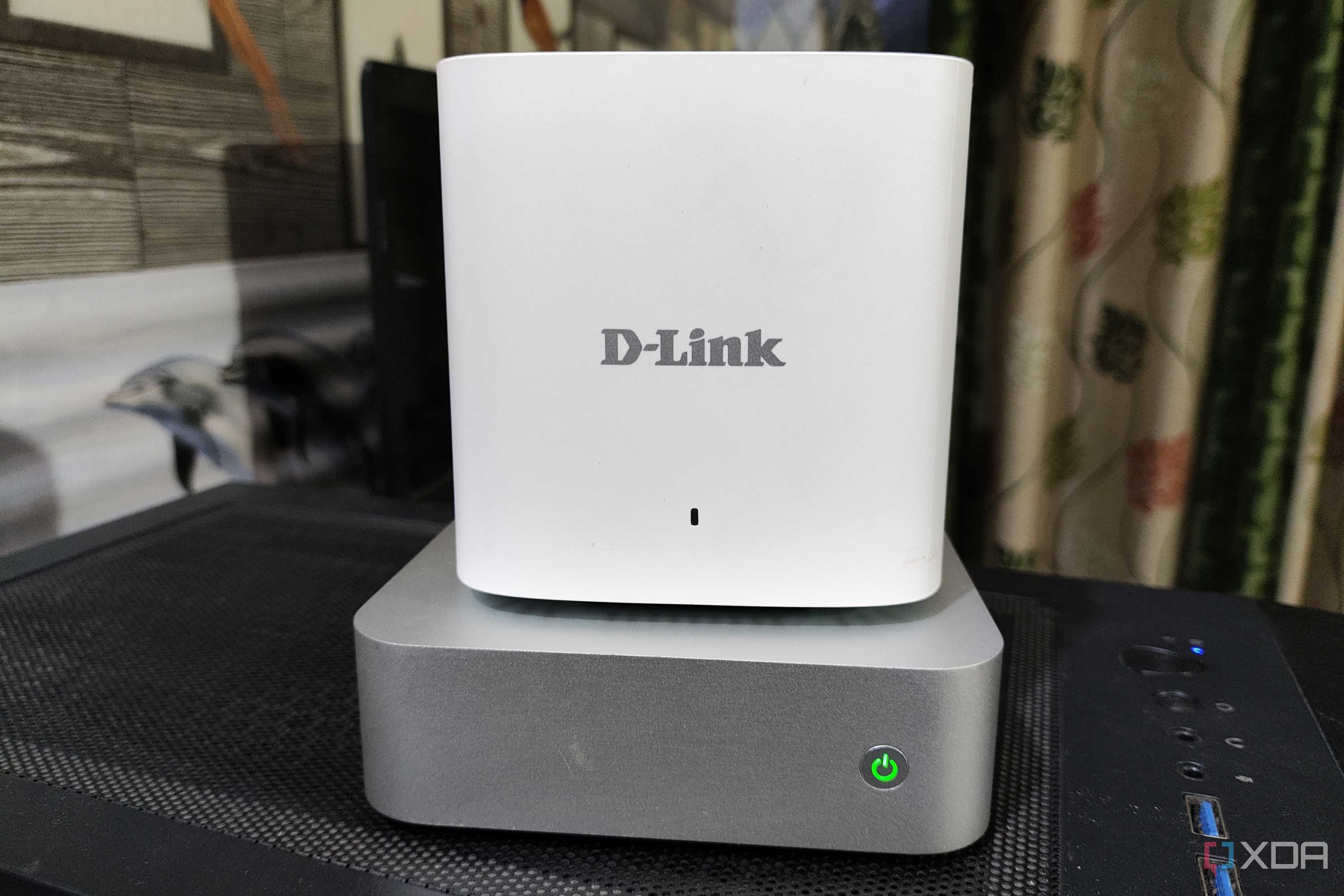 A D-Link mesh router placed on top of an Aiffro K100 NAS