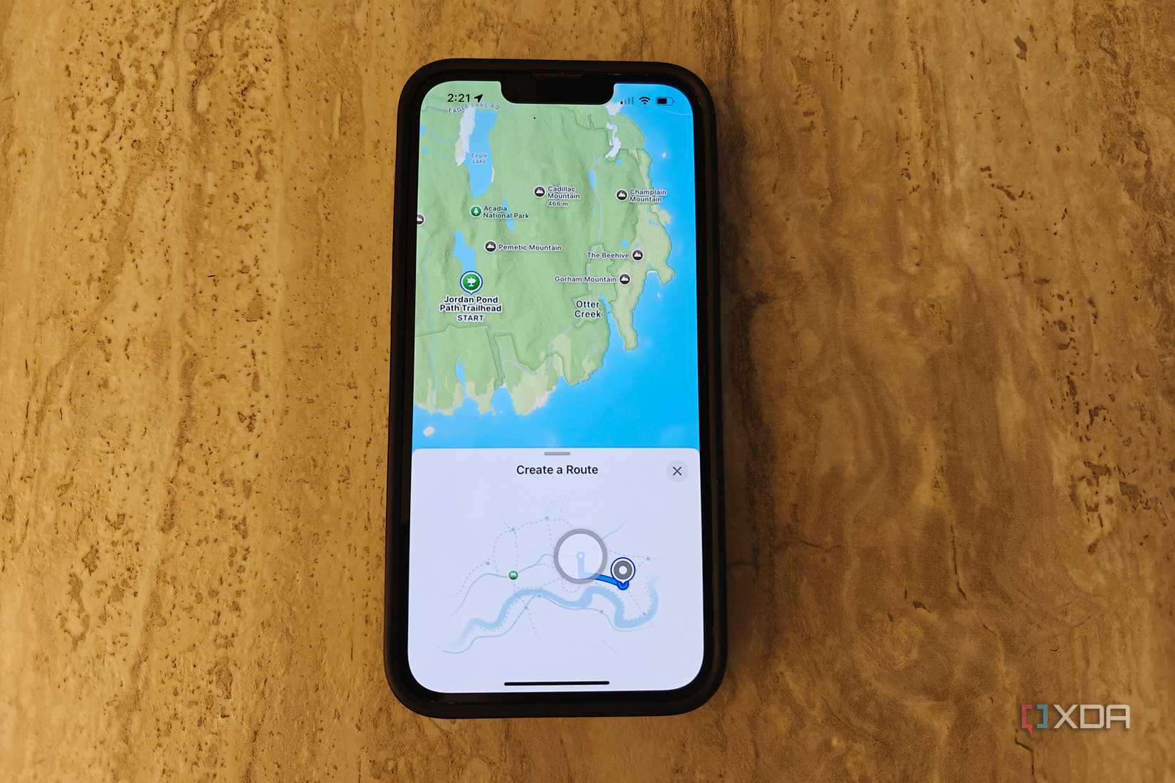 An iPhone on a table with the Apple Maps app open showing create a route