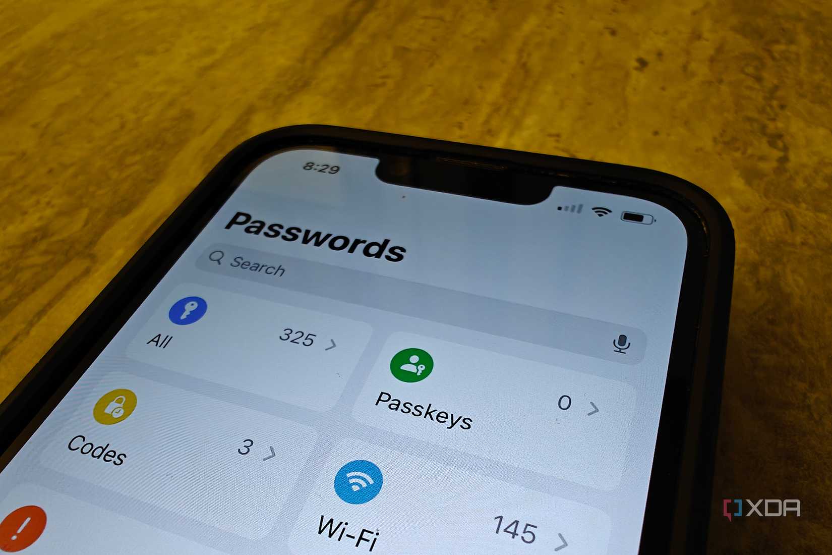 An iPhone on a table showing the Passwords app home screen