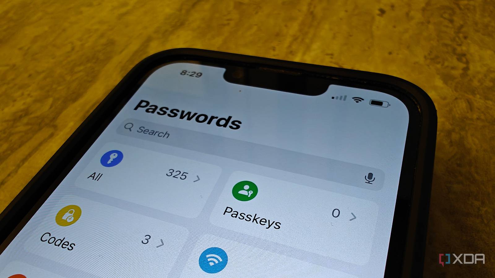 An iPhone on a table showing the Passwords app home screen