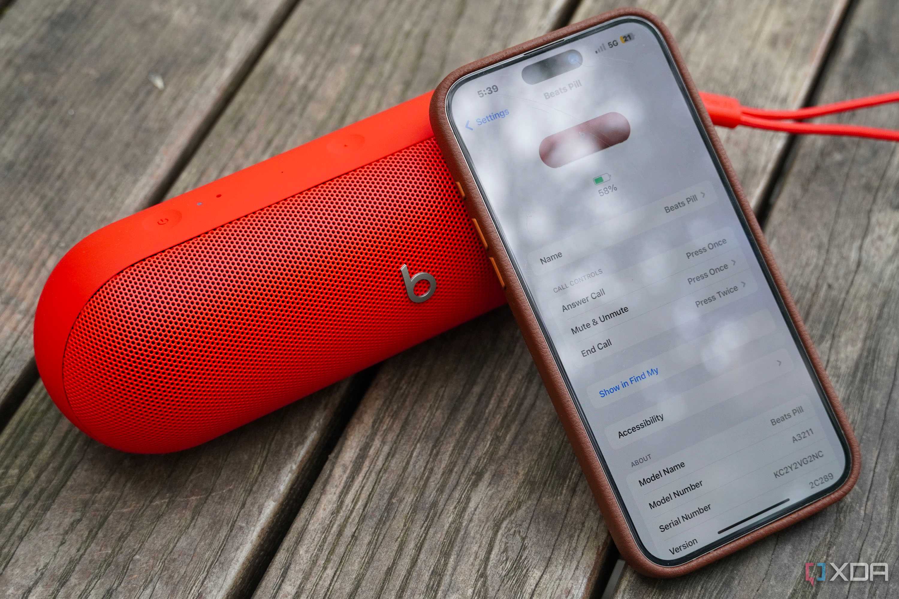 An iPhone leaning on a Beats Pill speaker.