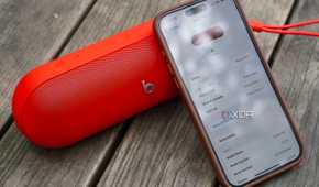 An iPhone leaning on a Beats Pill speaker.