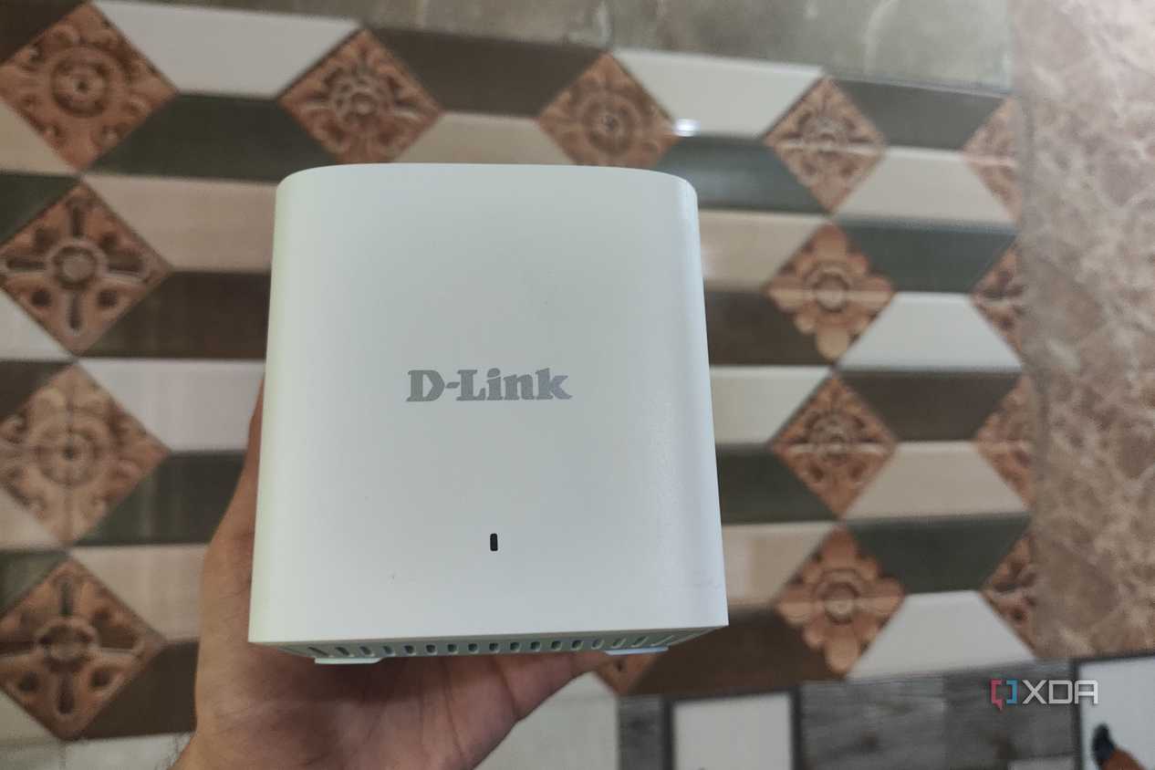 A person holding a M15/2 Eagle Pro AI Mesh router
