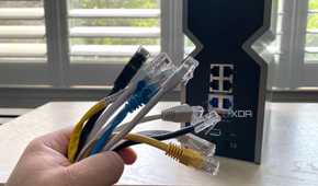 A number of ethernet cables infront of the rear ports of WI-FI 7 router