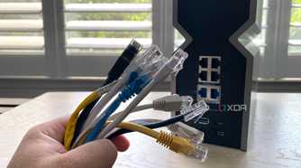 A number of ethernet cables infront of the rear ports of WI-FI 7 router
