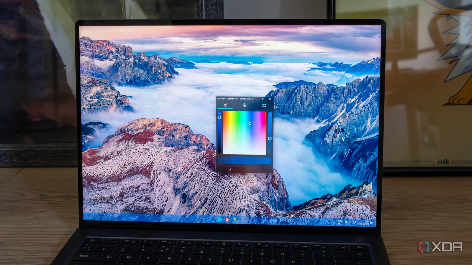A laptop with a Windows 11 desktop with TranslucentTB changing the color and transparency of the taskbar
