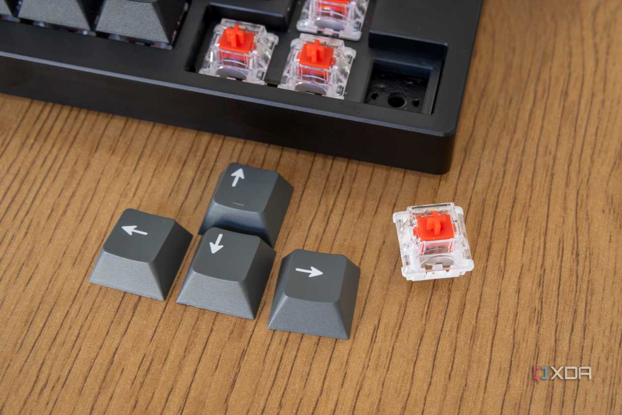 Close-up of the keycaps for the arrow keys on the Lemokey P1 Pro with one removed switch next to it