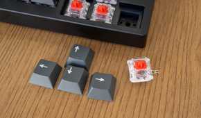 Close-up of the keycaps for the arrow keys on the Lemokey P1 Pro with one removed switch next to it