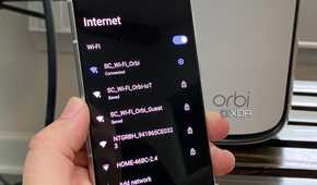 Netgear router with IoT, Guest, and standard Wi-Fi shown on an Android phone