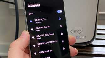 Netgear router with IoT, Guest, and standard Wi-Fi shown on an Android phone