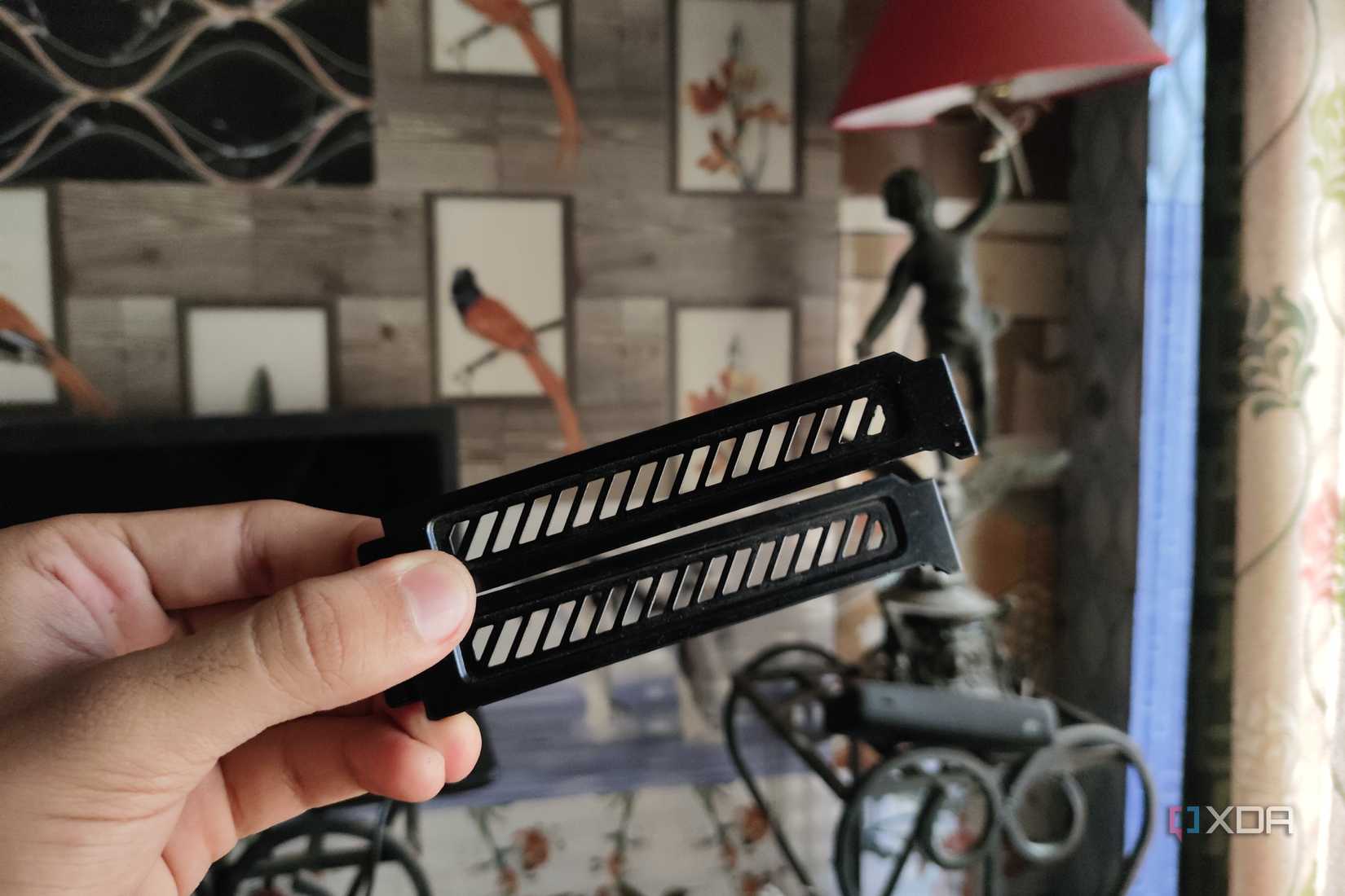 A person holding two PCIe expansion slot covers