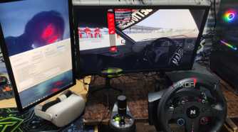 Assetto Corsa running in VR mode, with a Nitho Pro Driving Wheel and Meta Quest 2 lying next to the monitors