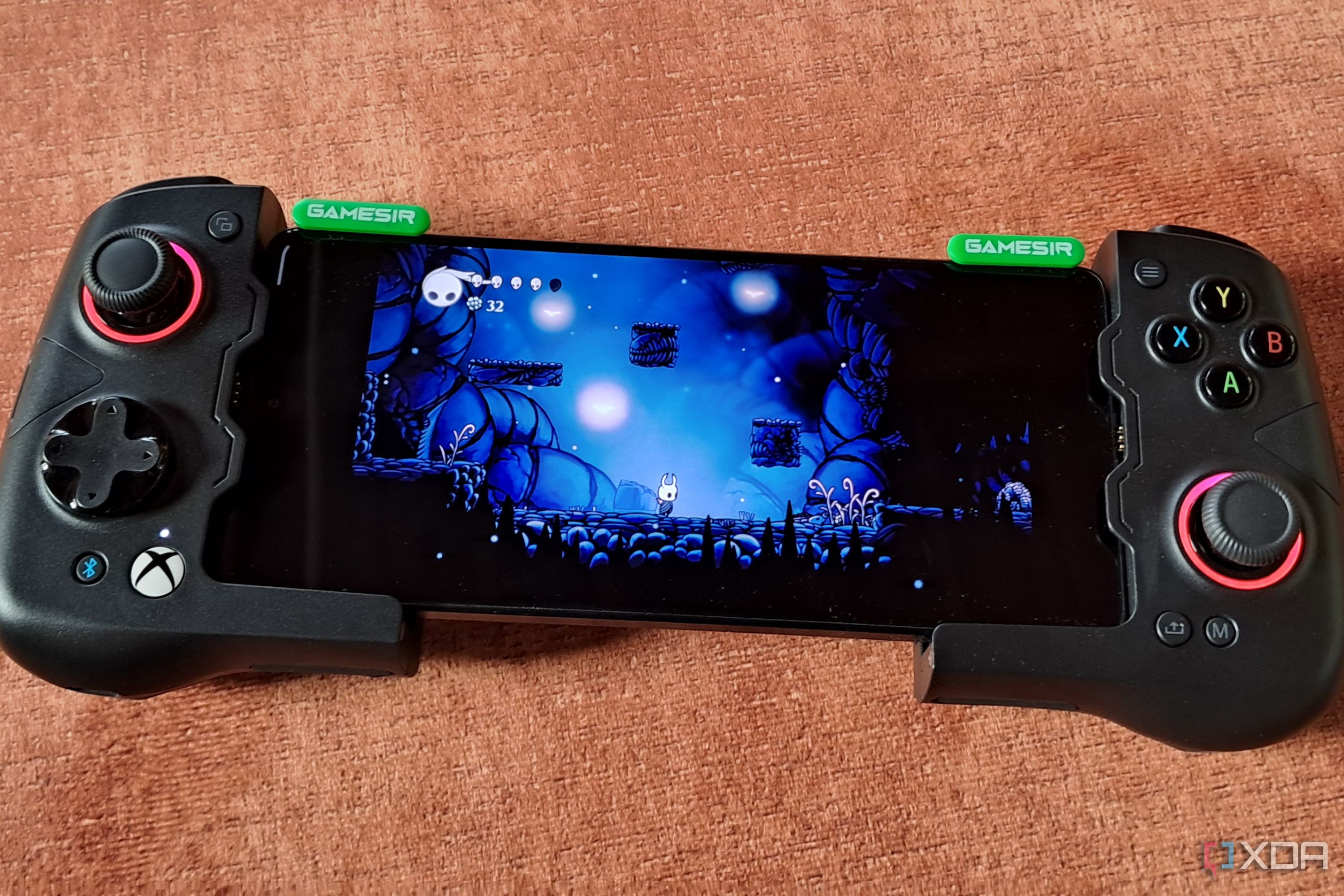 A GameSir X4 Aileron controller connected to a Poco F5, with the phone running Hollow Knight via Winlator
