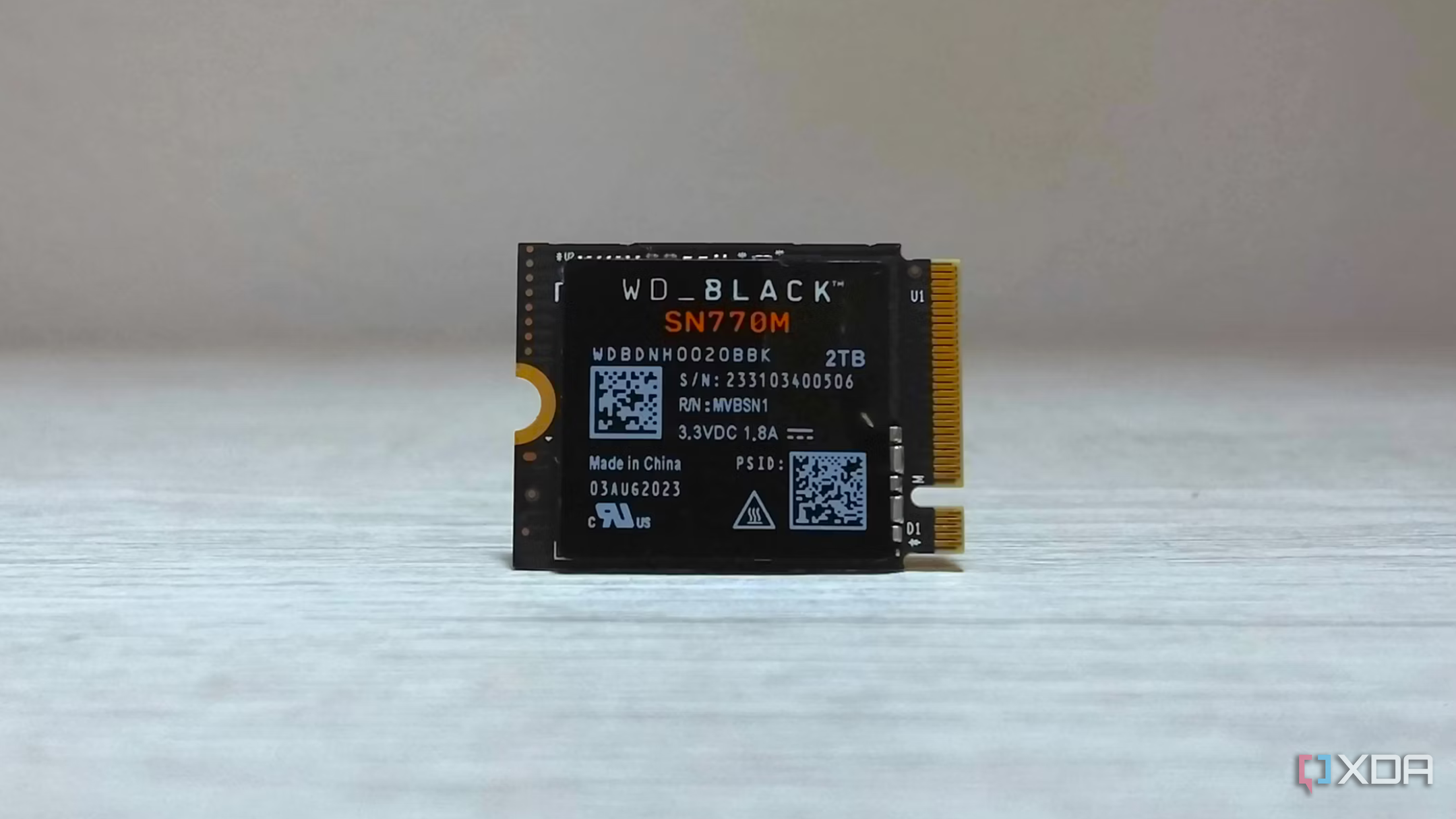 An image of a WD SN770M SSD on a table in an upright position. 