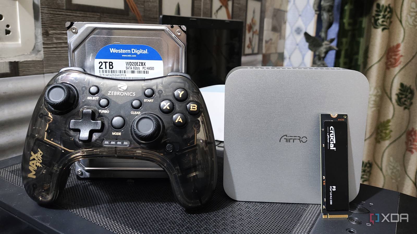 An Aiffro K100 NAS with a controller, an HDD, and an SSD kept nearby