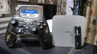 An Aiffro K100 NAS with a controller, an HDD, and an SSD kept nearby