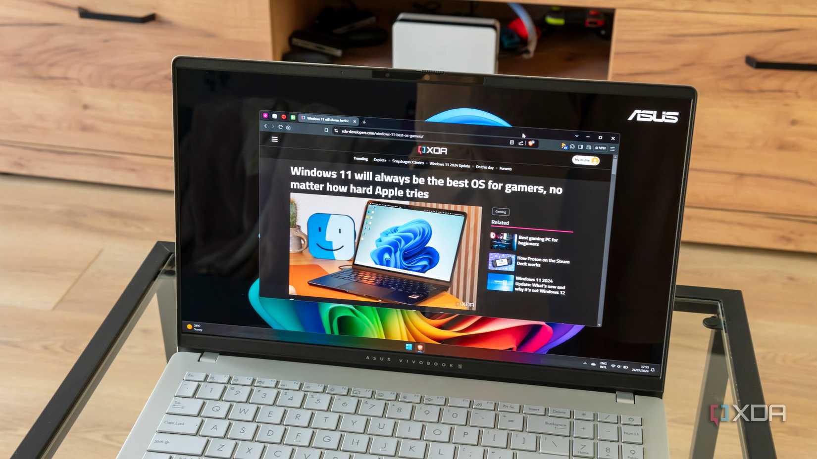 Angled view of the Asus Vivobook S 15 displaying an XDA article in Brave Browser
