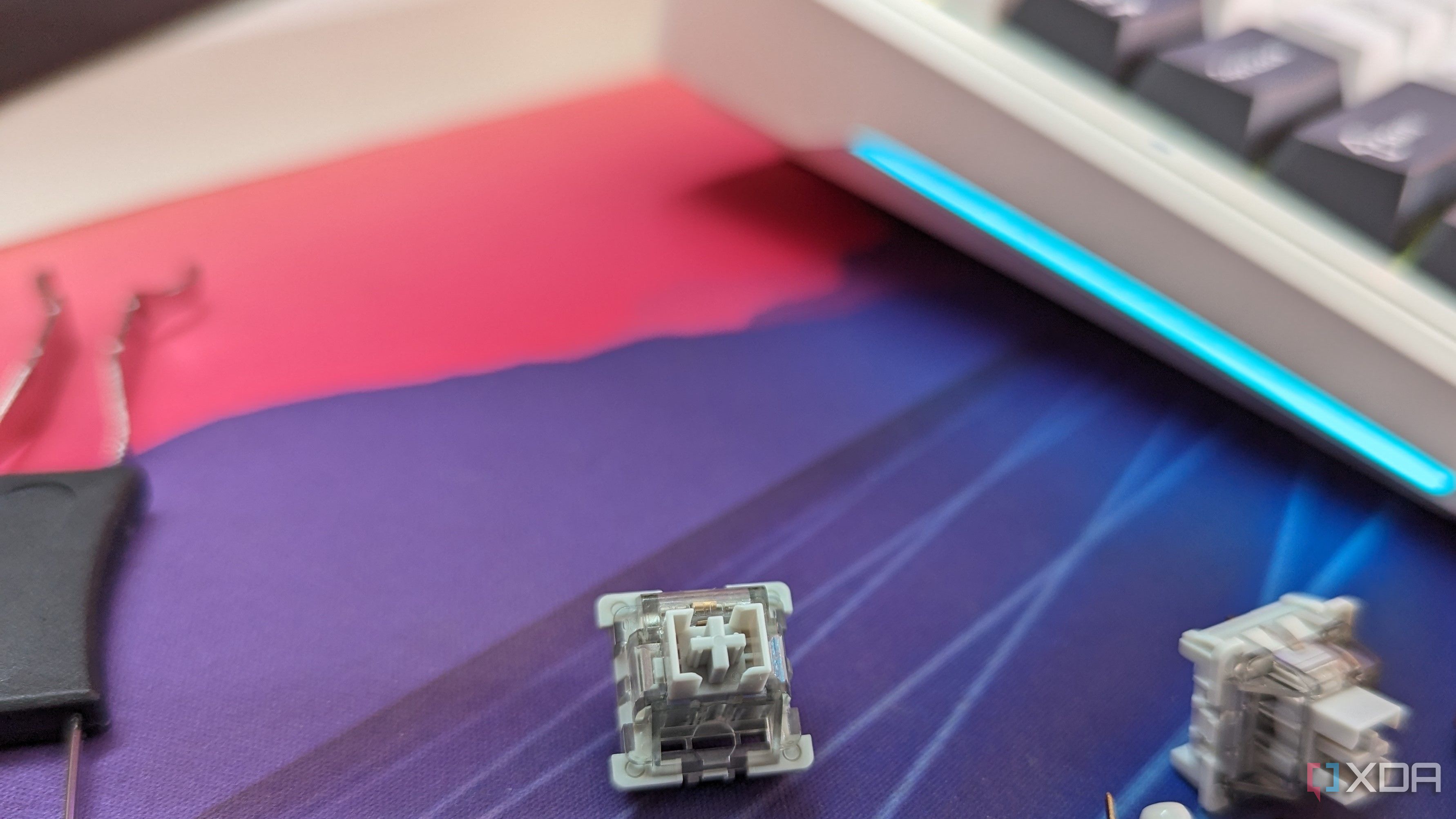 Close-up of a grey-colored mechanical switch next to a keyboard