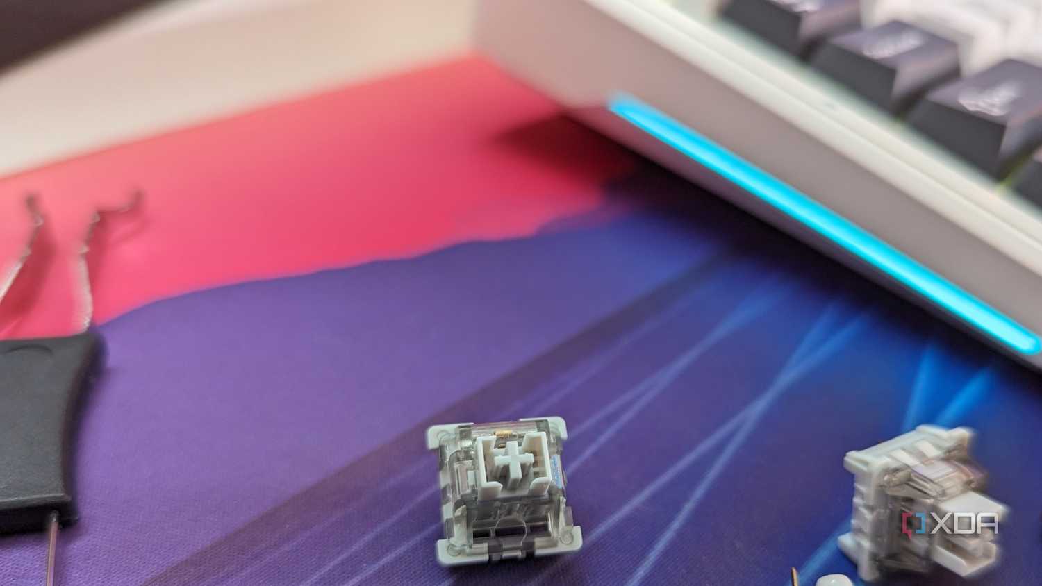 Close-up of a grey-colored mechanical switch next to a keyboard