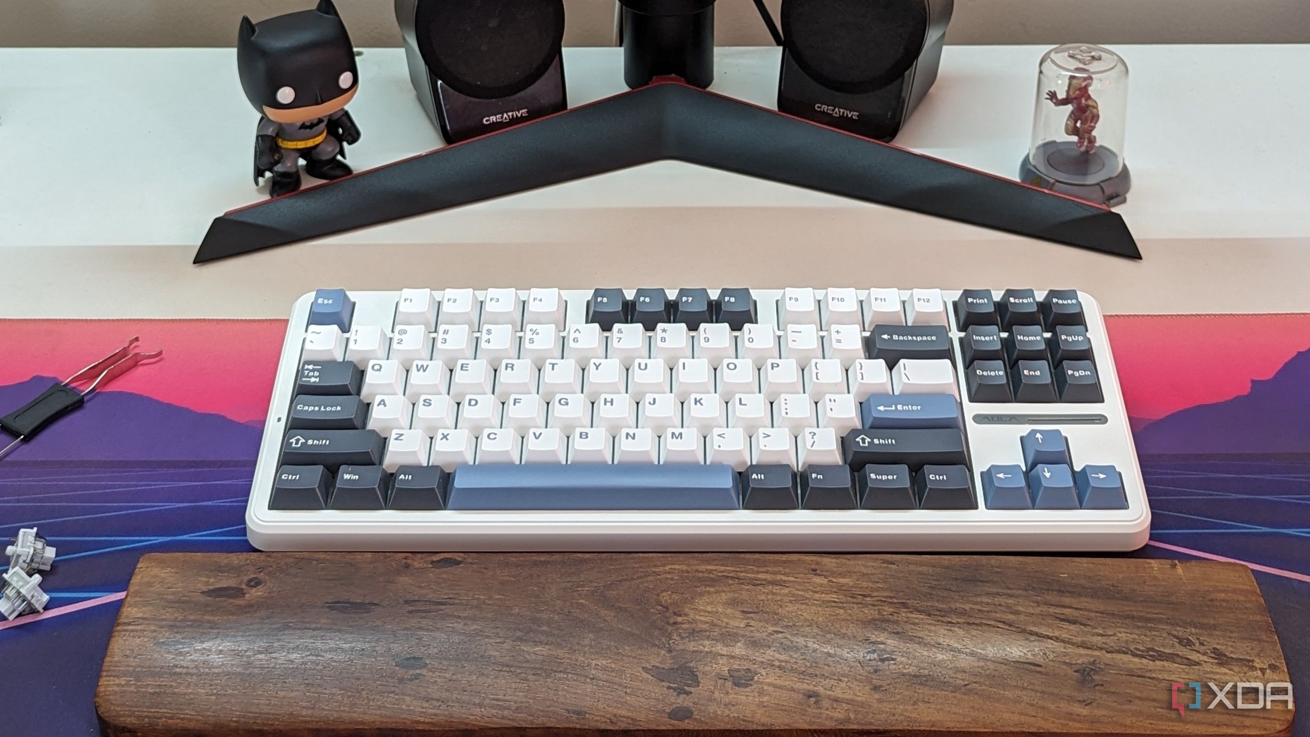 A keyboard and a wristrest on a desk mat