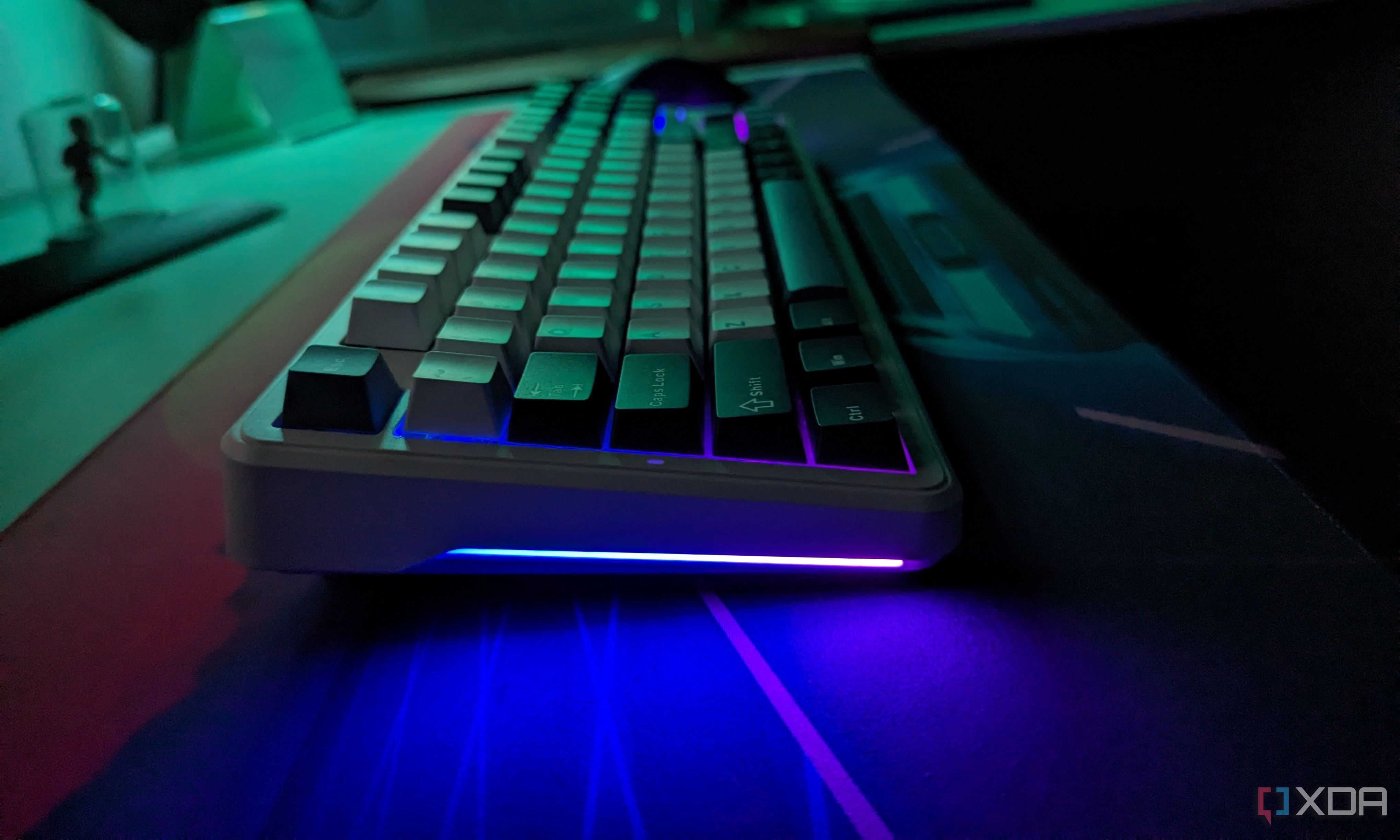 A keyboard in a dark room whit RGB lighting on its side