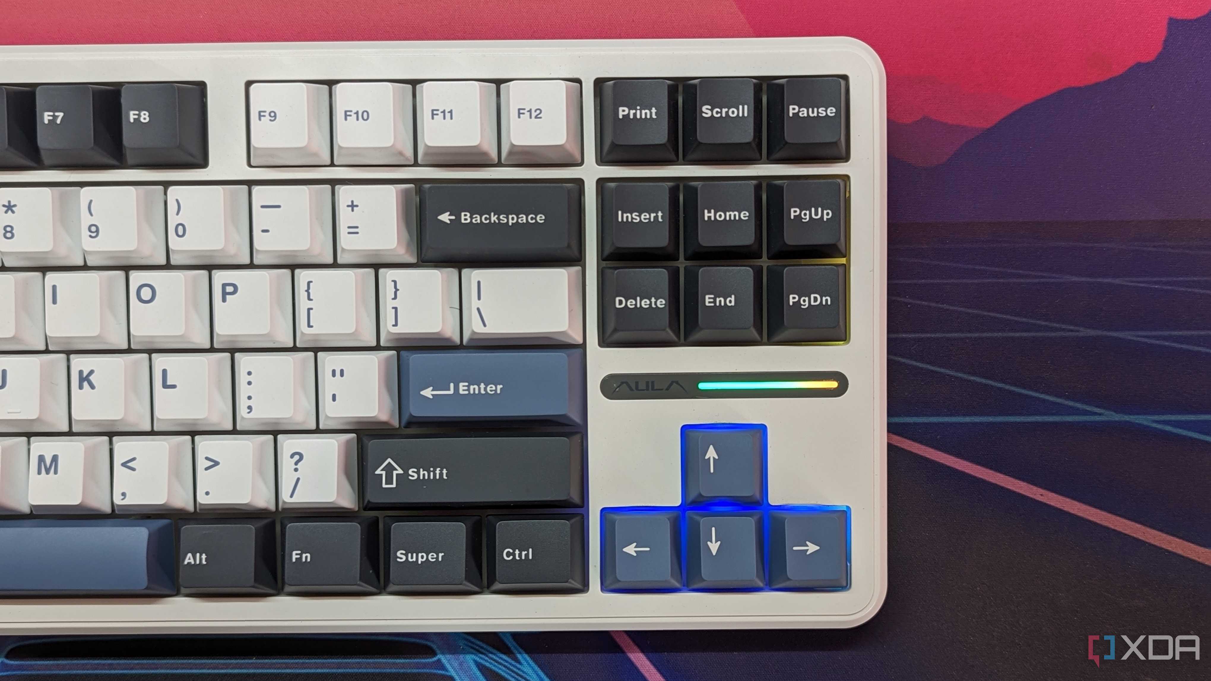 A keyboard shown from the top with RGB lighting on the arrow keys